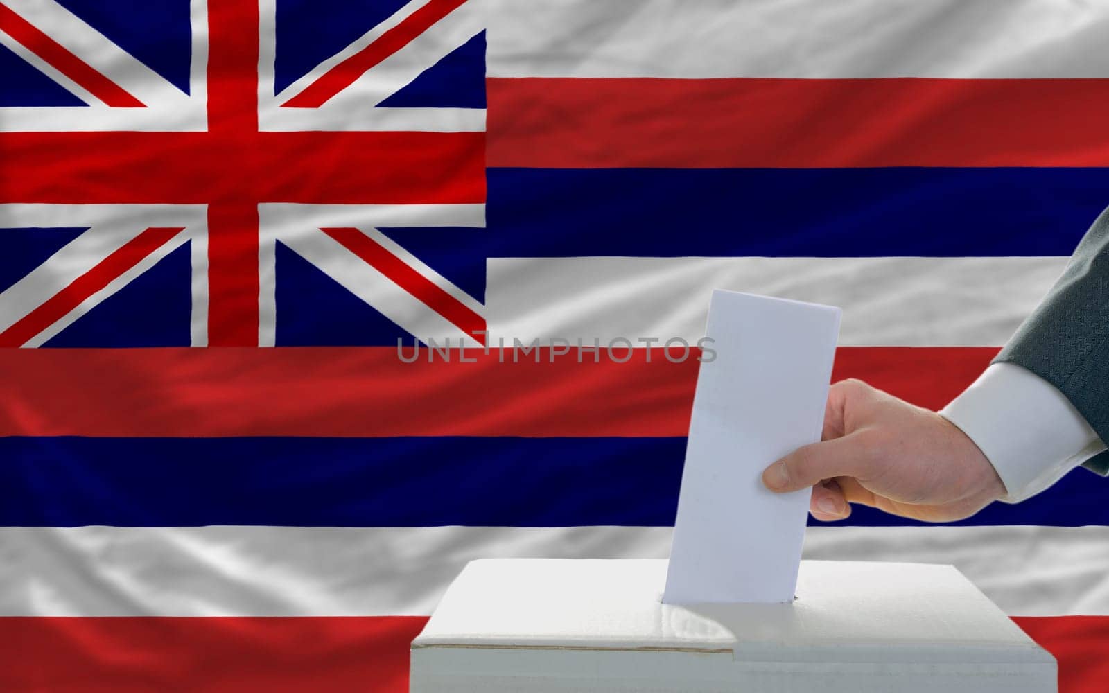 man putting ballot in a box during elections  in front of flag american state of hawaii