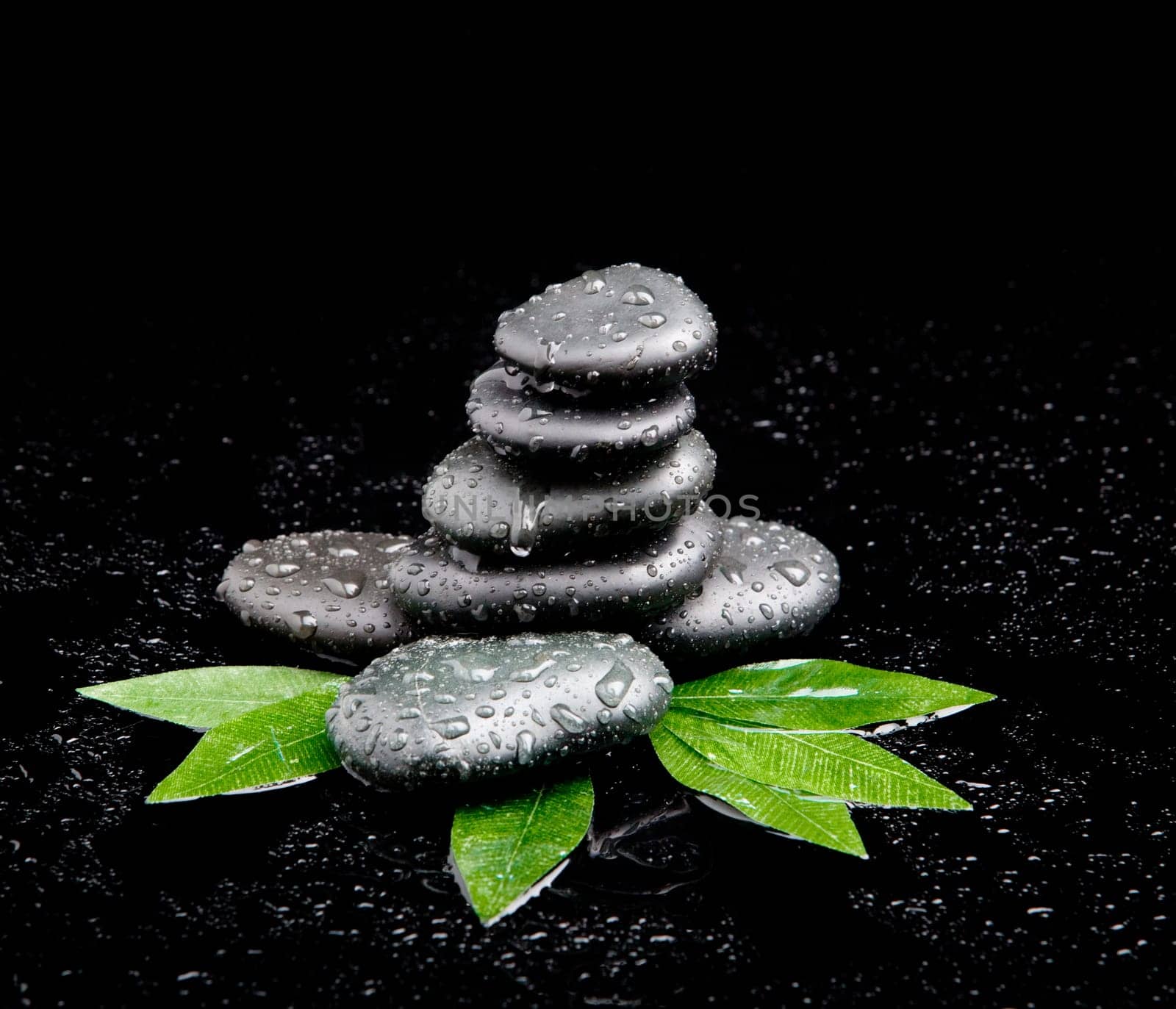 black stone with leaf. massage stones