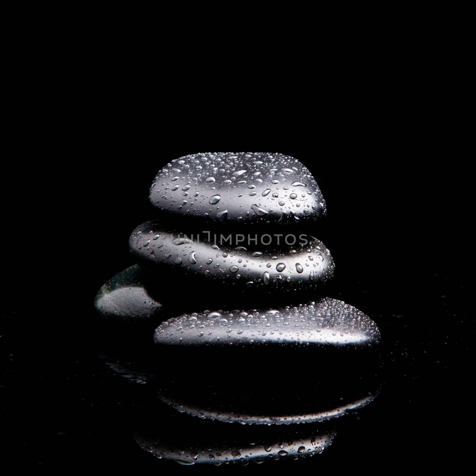 Spa Stones. black shiny zen stones with water drops over black background