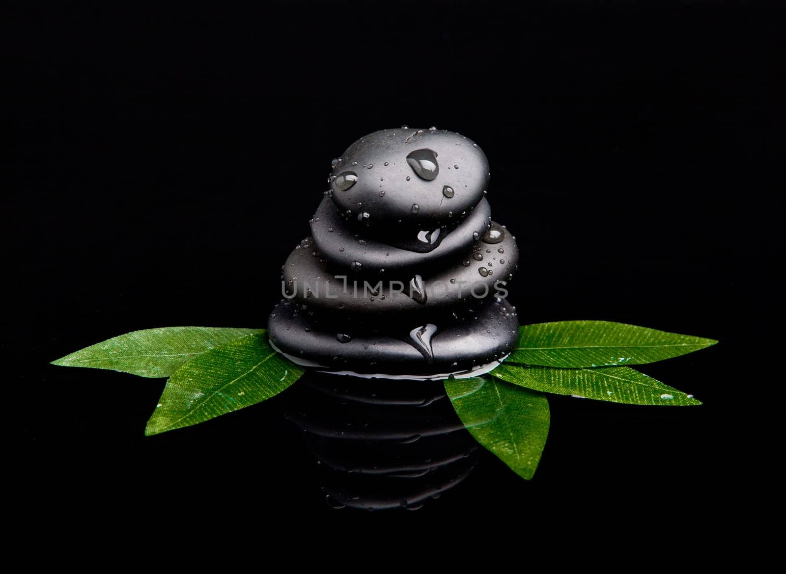black stone with leaf. massage stones