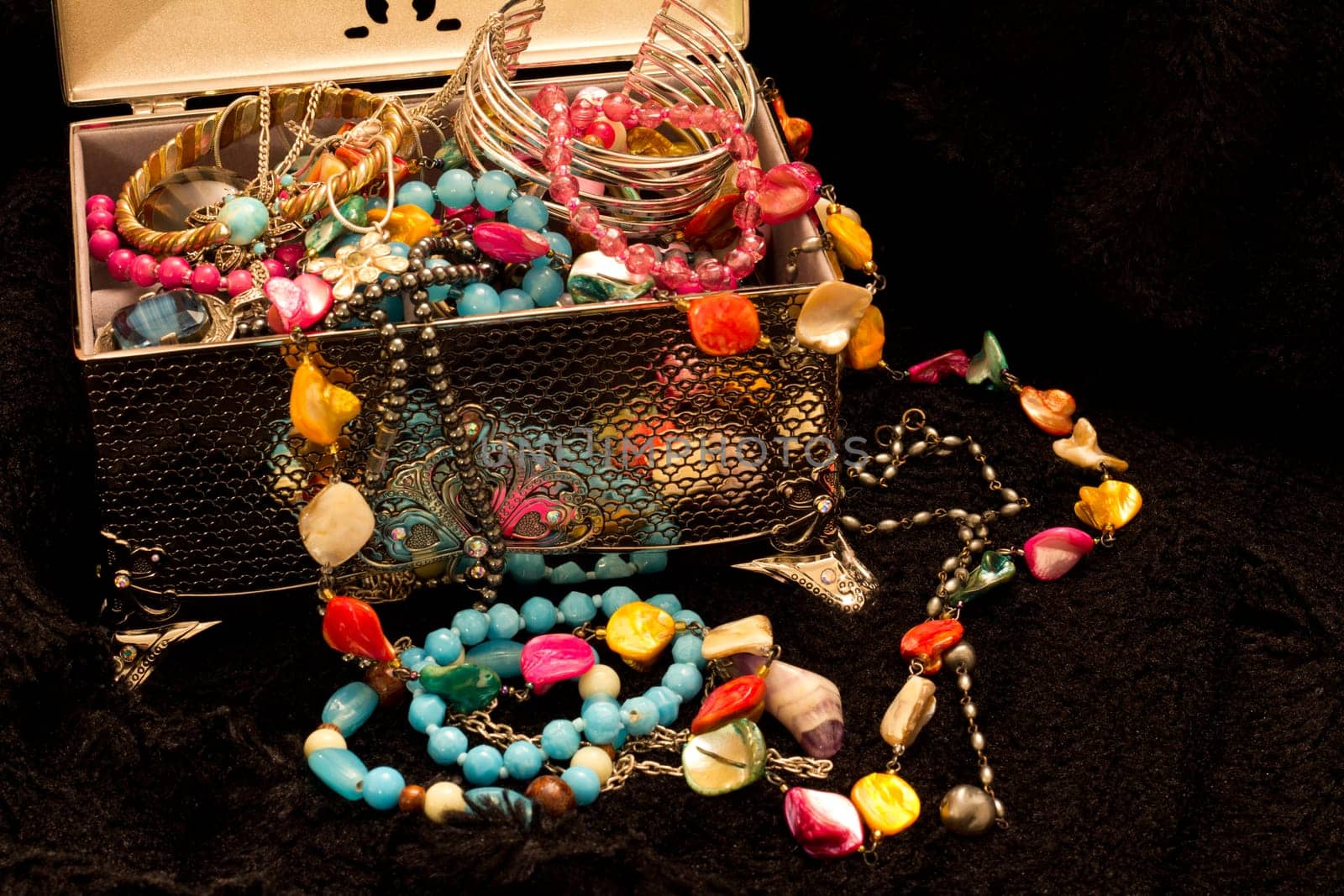 A silver case spilling brightly colored trinkets