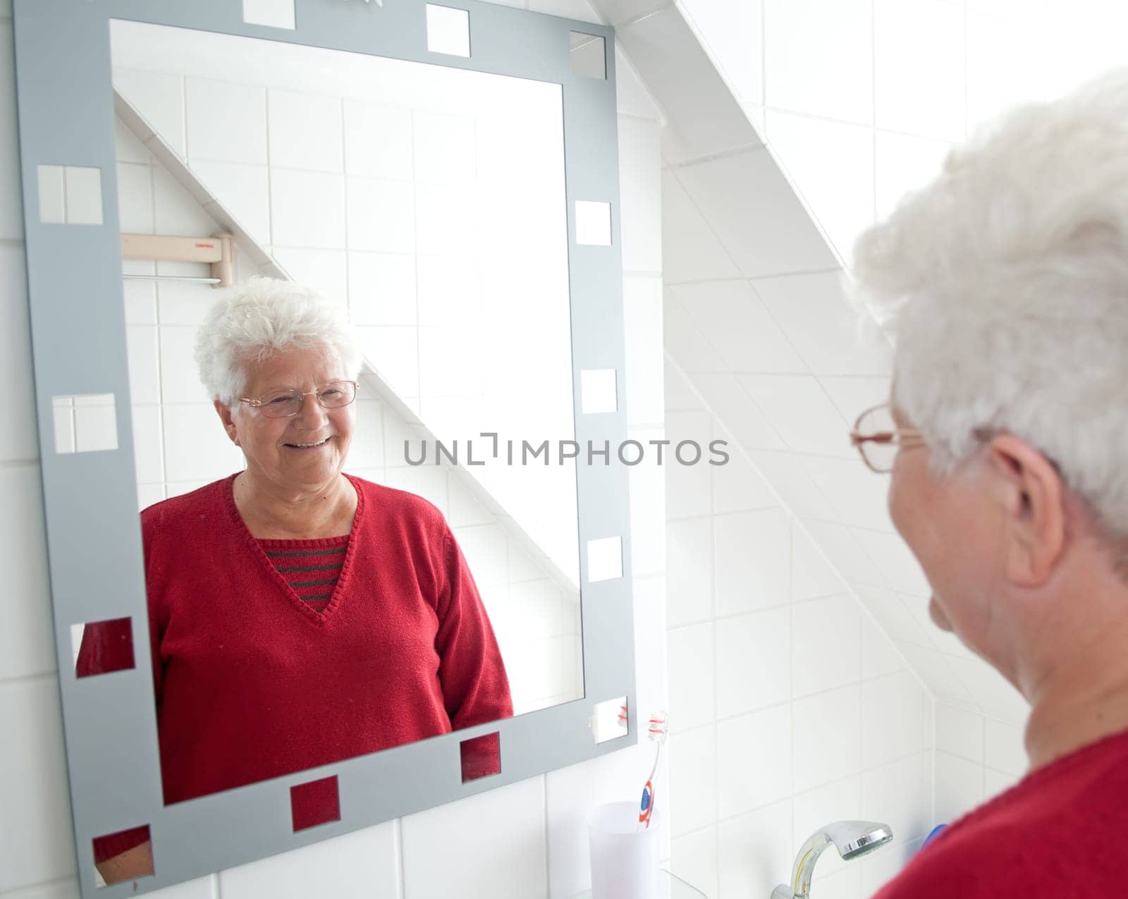 Cheerful pensioner looking in the mirror