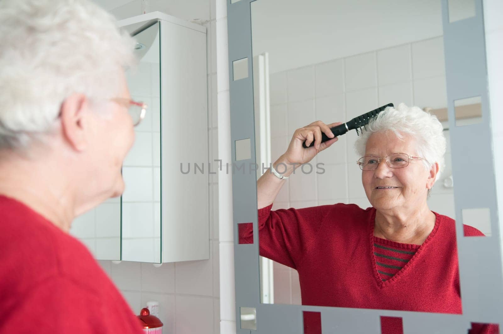 Senior woman combing her hair