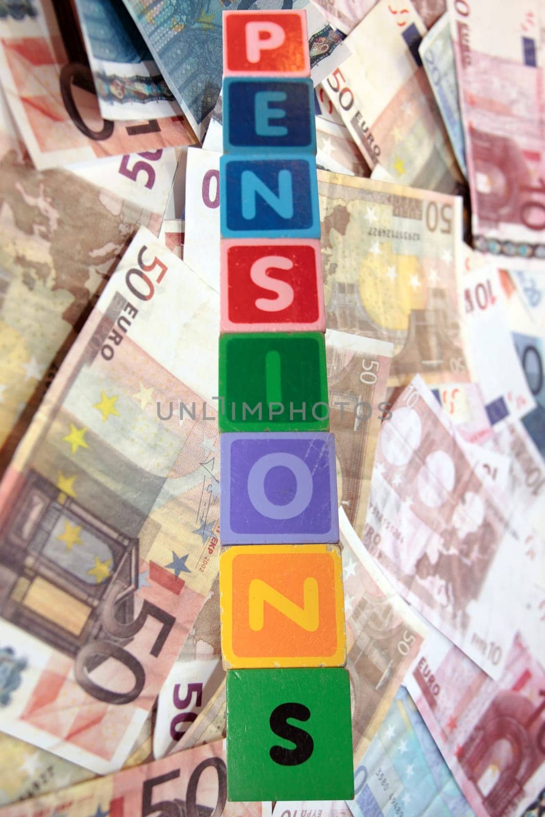 toy letters that spell pensions against a cash background with clipping path