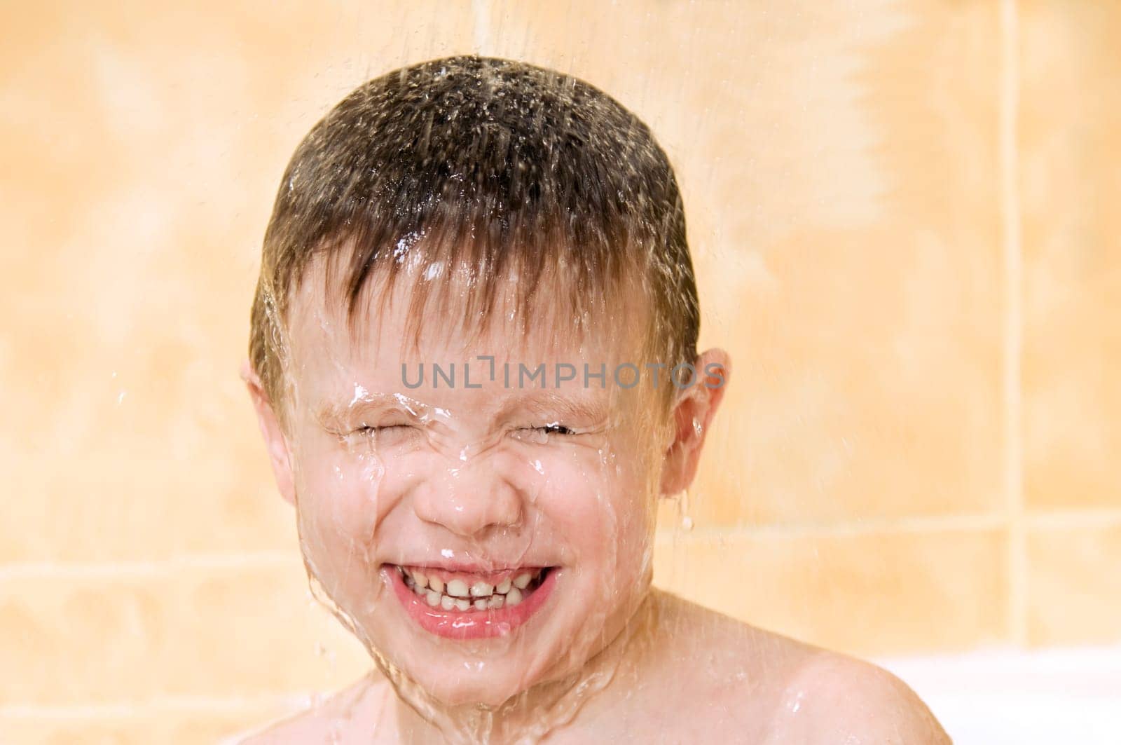 A smiling child washing in the shower