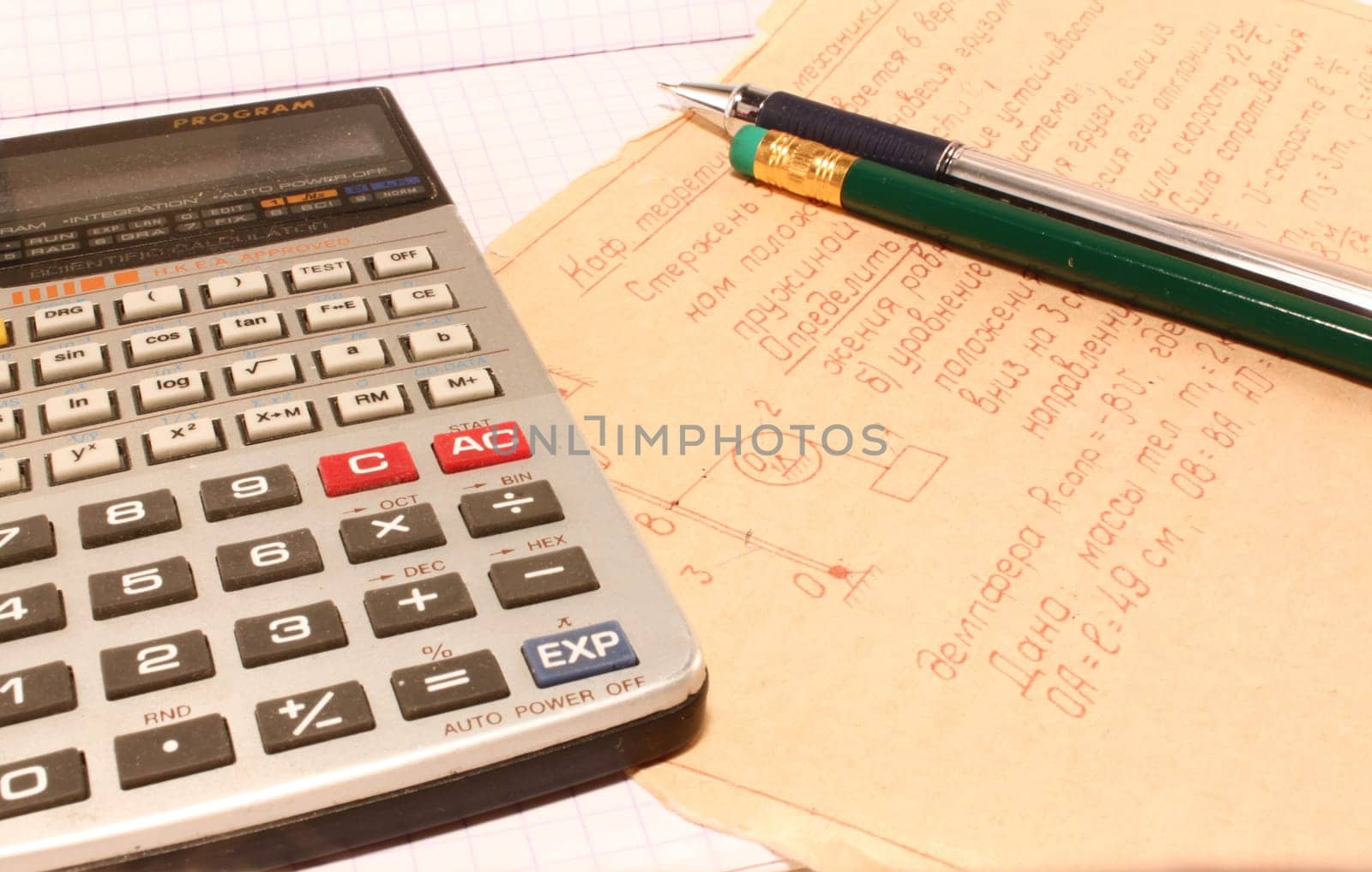 Leaf with a homework, the calculator and a pen