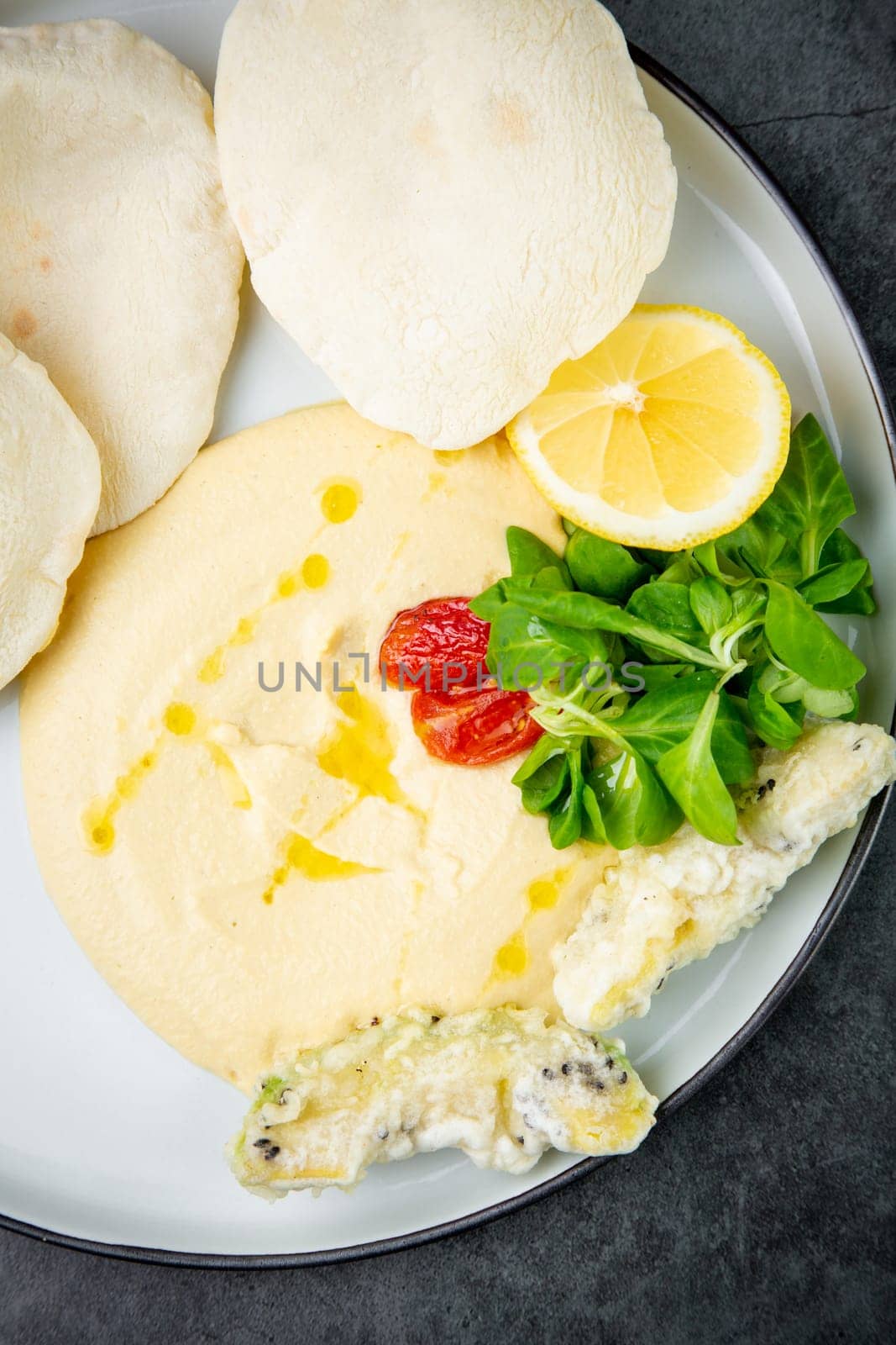 fish steak with rice cakes, cherry tomatoes, lemon and herbs, top view by tewolf