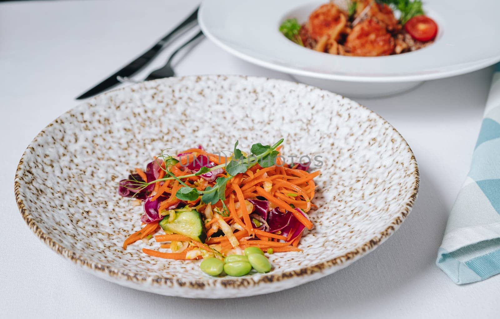 carrot salad with cucumbers, beans and herbs, side view by tewolf