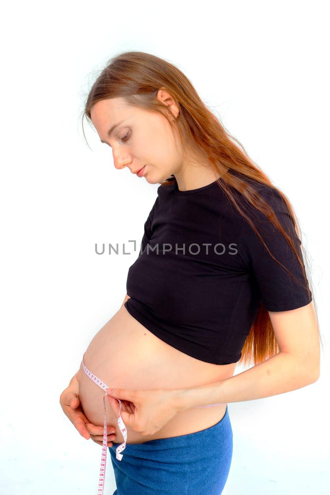 Pregnant woman measuring stomach with measuring tape. High quality photo