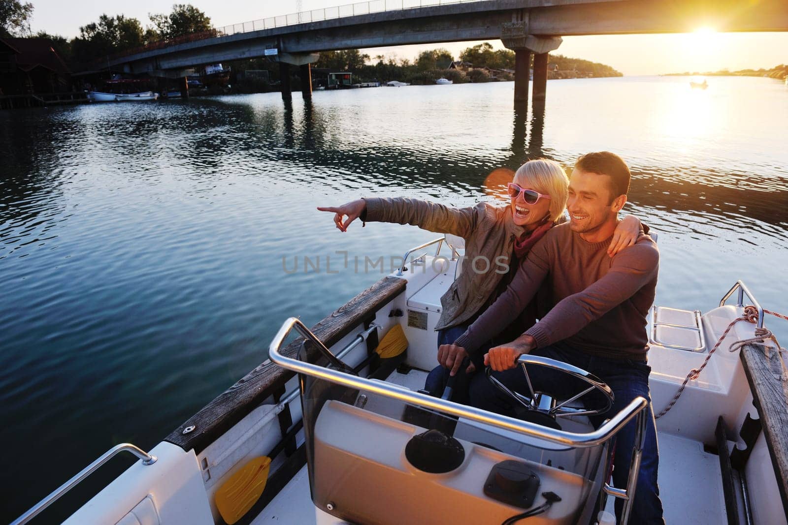 happy young couple in love  have romantic time at summer sunset   at ship boat while  representing urban and countryside fashin lifestyle