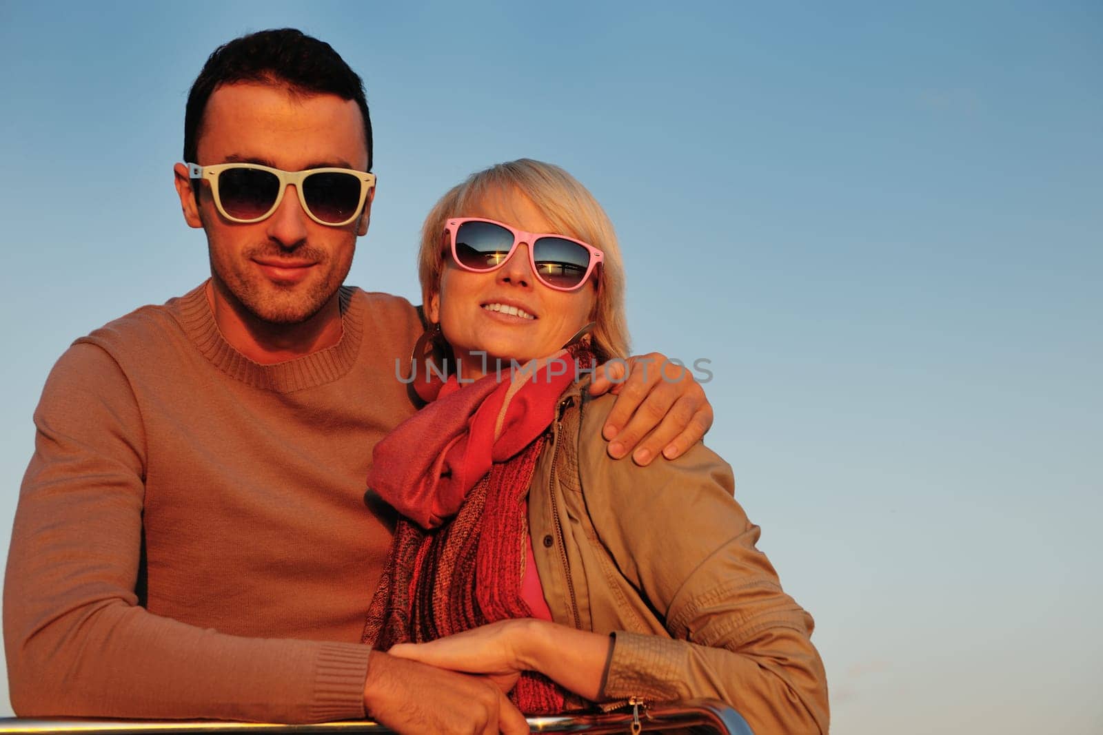 happy young couple in love  have romantic time at summer sunset   at ship boat while  representing urban and countryside fashin lifestyle