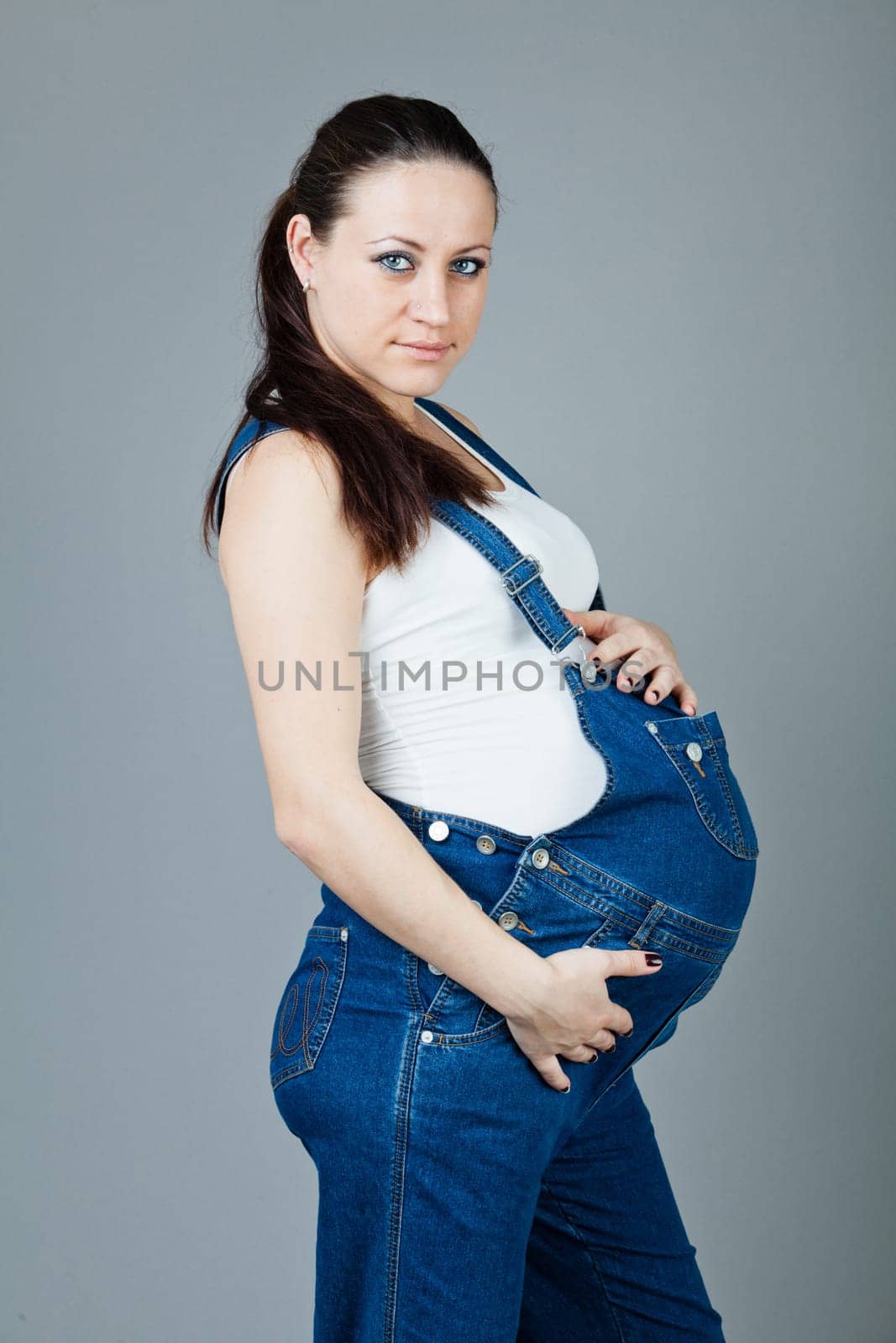 beautiful young pregnant woman with a gray background