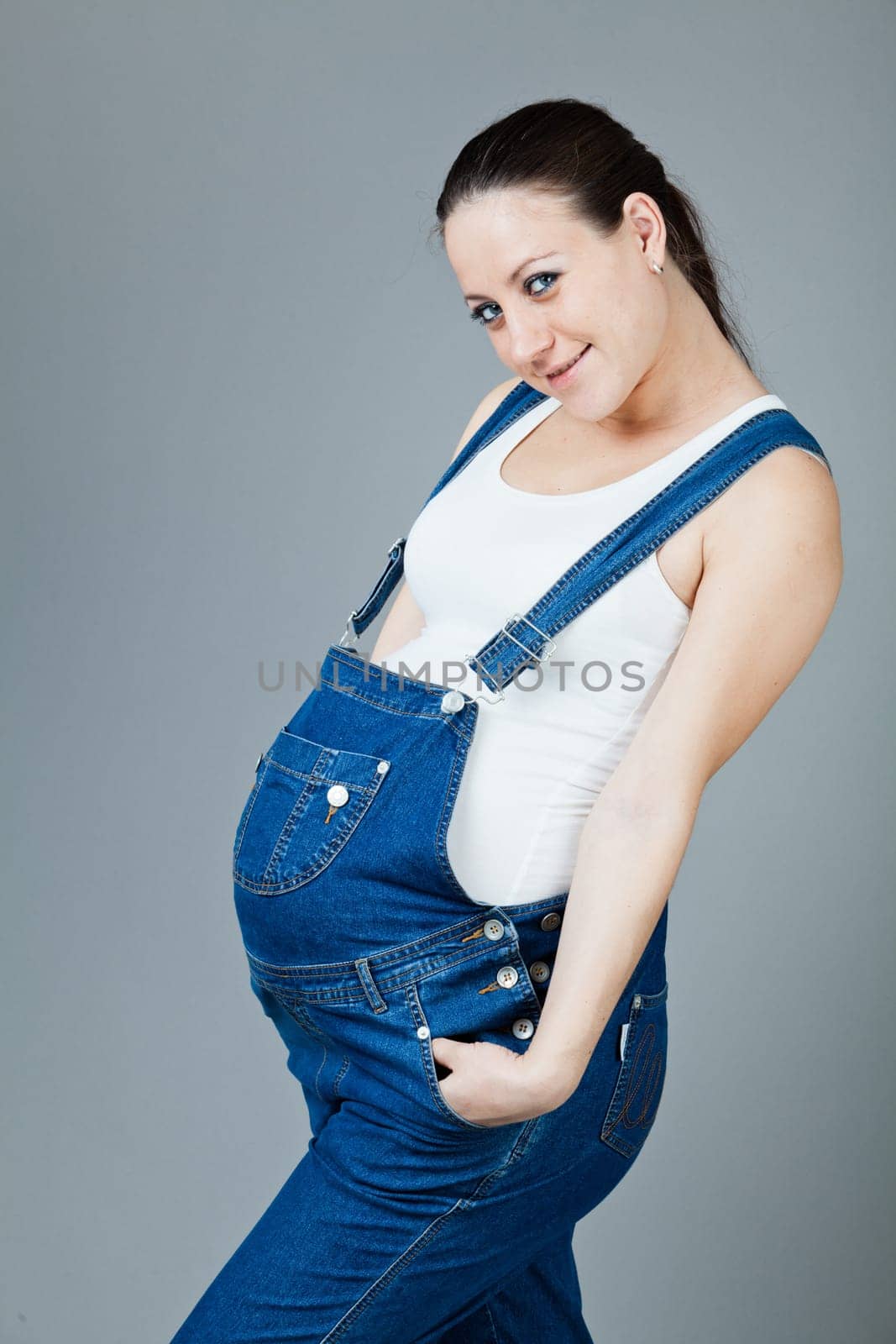 beautiful young pregnant woman with a gray background