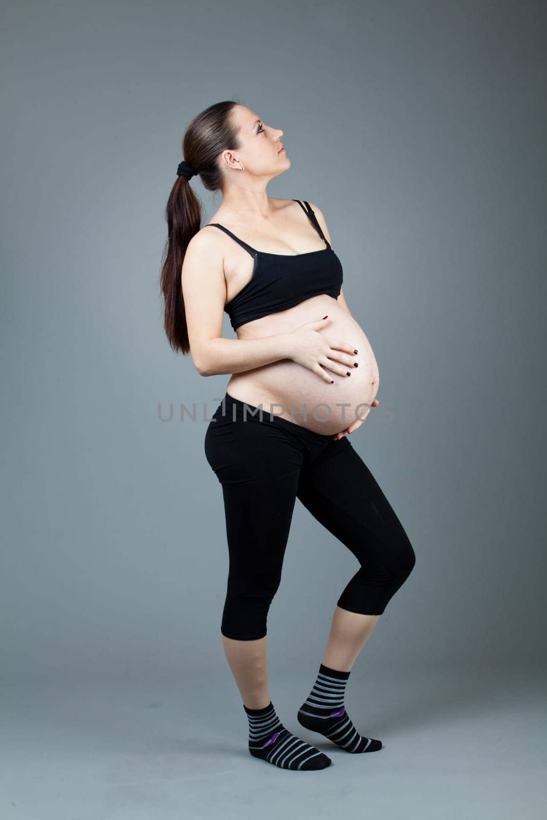 beautiful young pregnant woman with a gray background