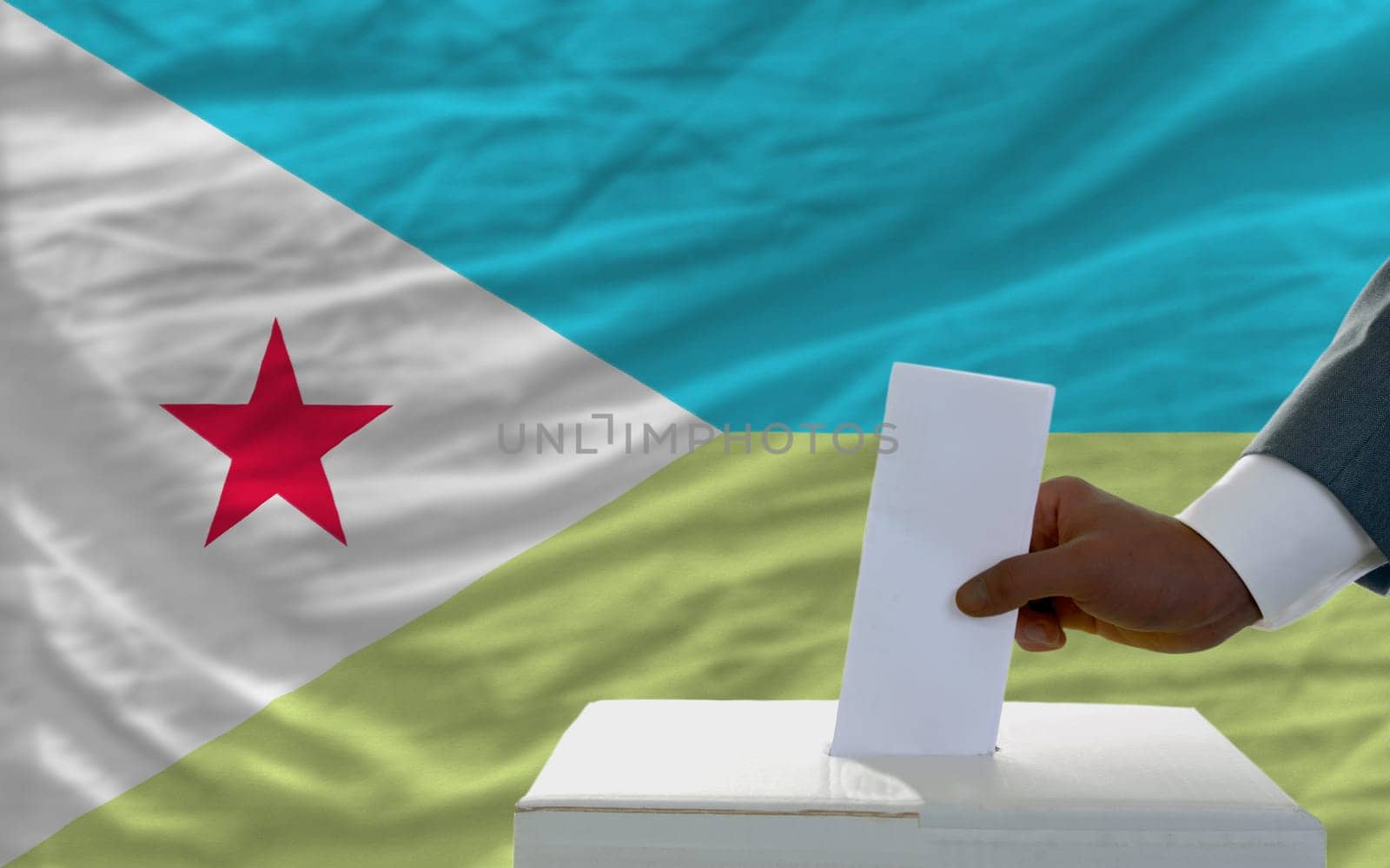 man putting ballot in a box during elections  in front of national flag of djibuti