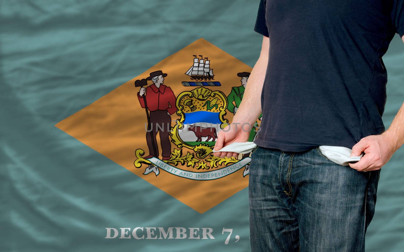 poor man showing empty pockets in front of delaware flag
