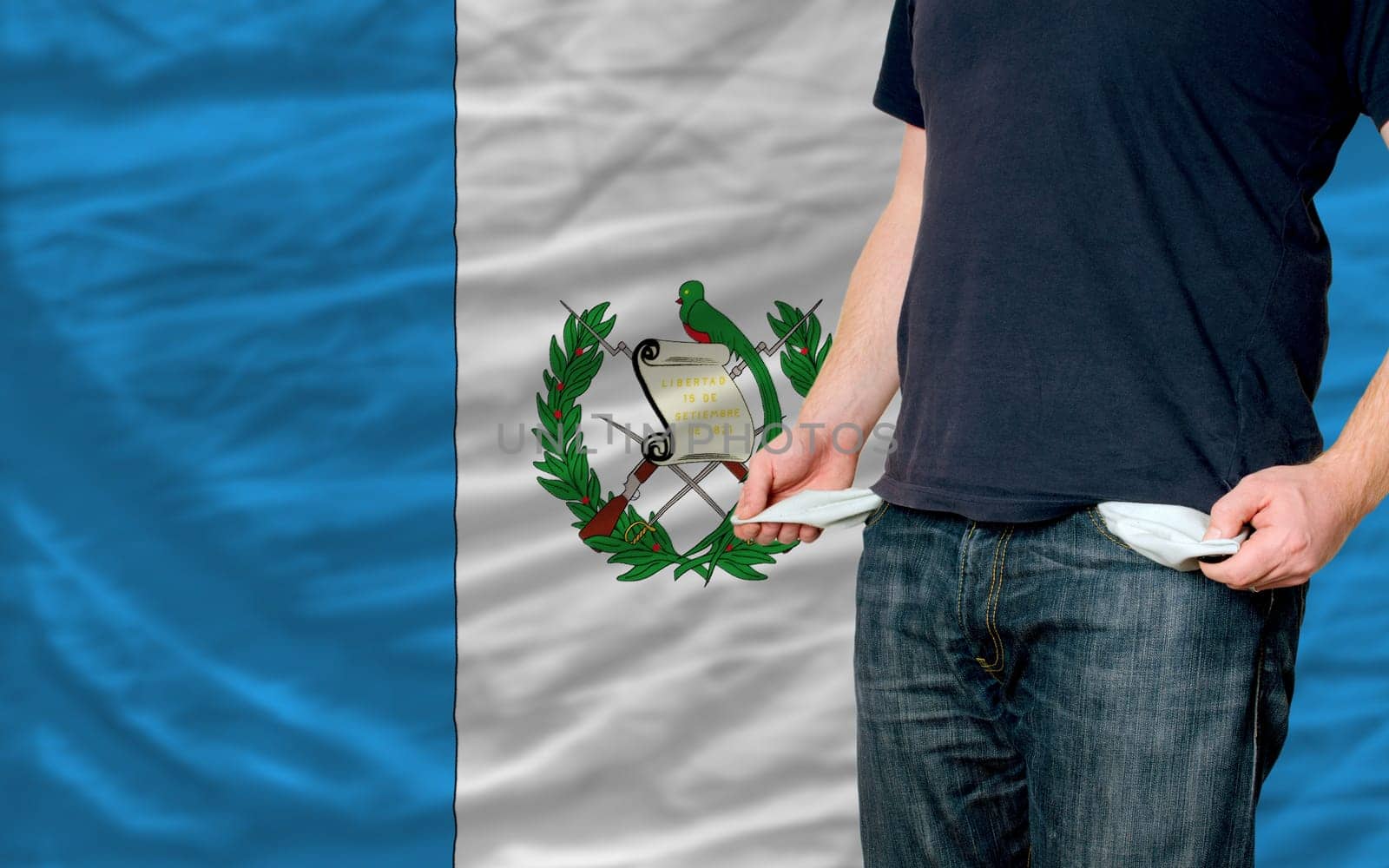 poor man showing empty pockets in front of guatemala flag