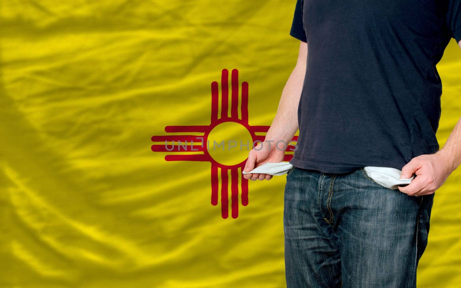 poor man showing empty pockets in front of american state of new mexicoflag