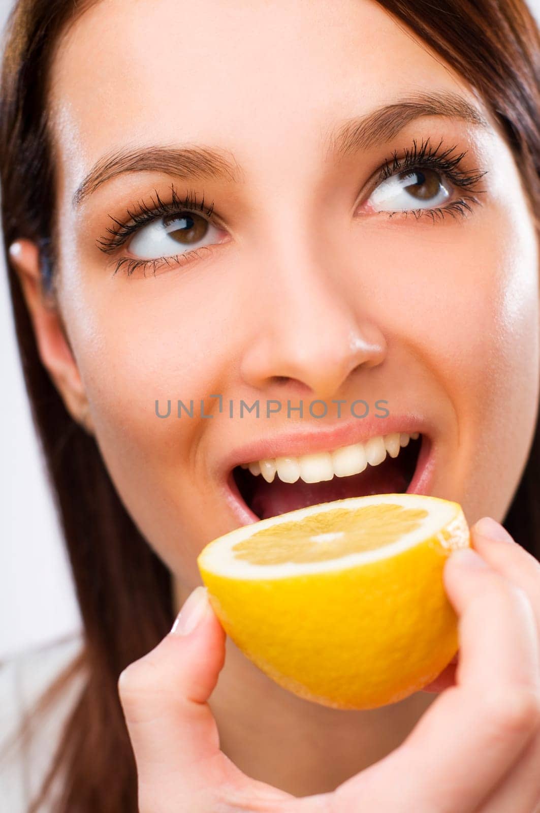Young woman eating lemon close up shoot