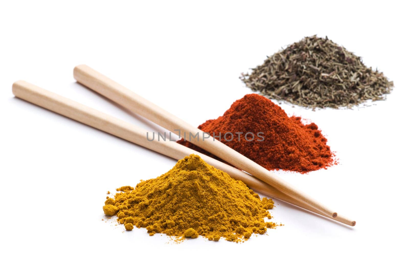 Heaps of various ground spices with chopsticks on white background