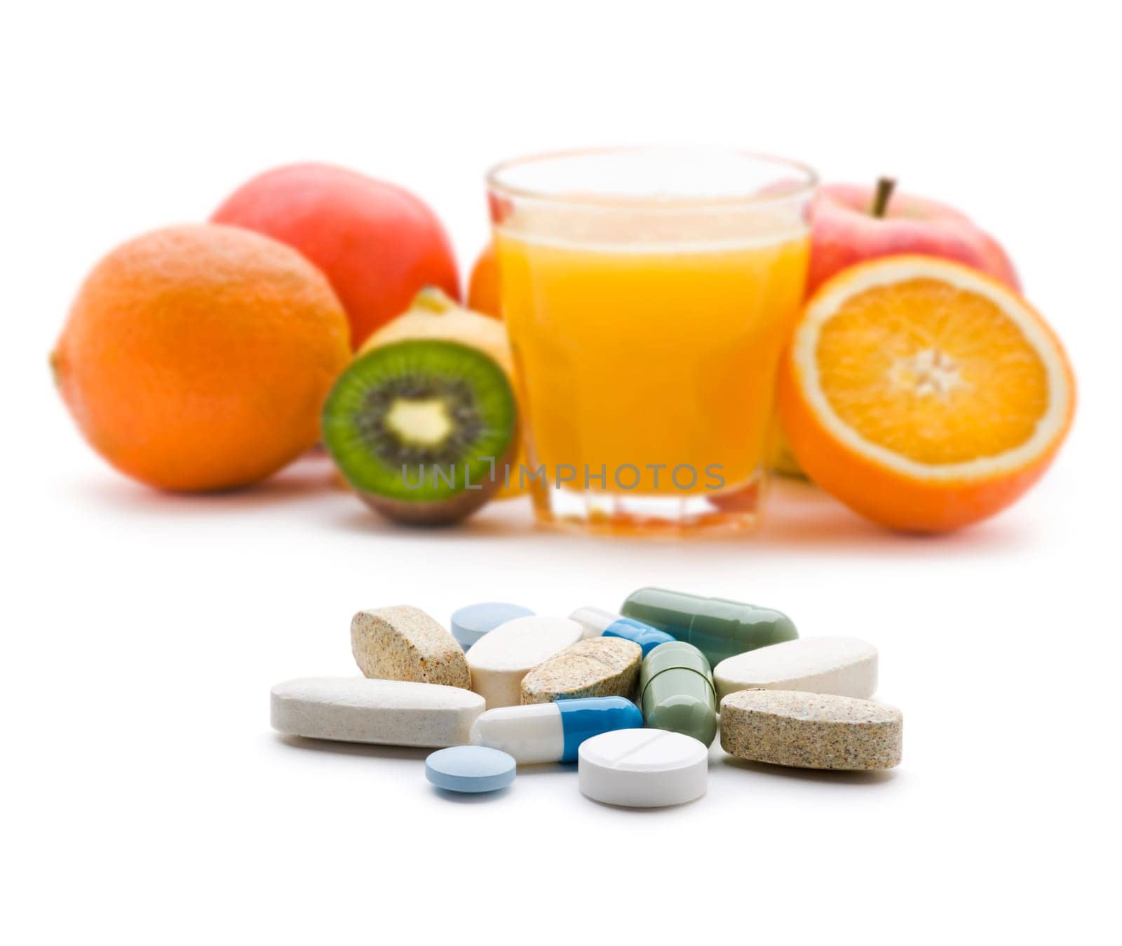 Pills with fresh fruit in background isolated