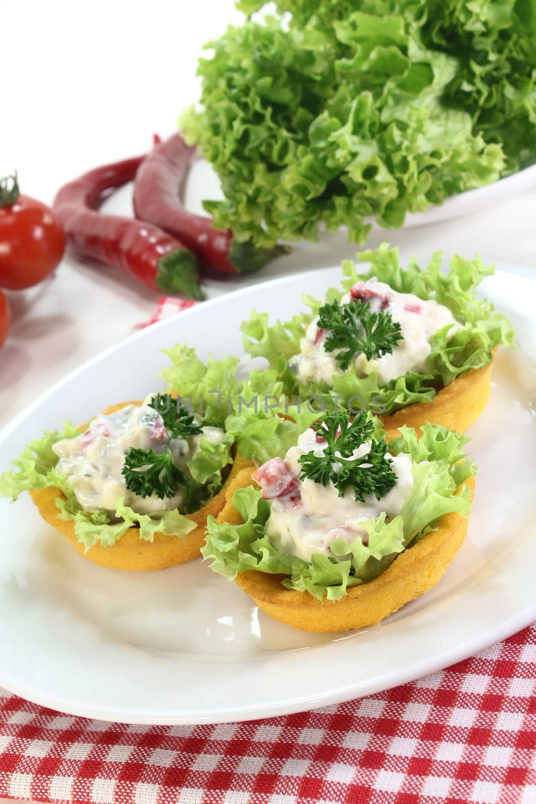 Corn tartlets with cheese salad against white background