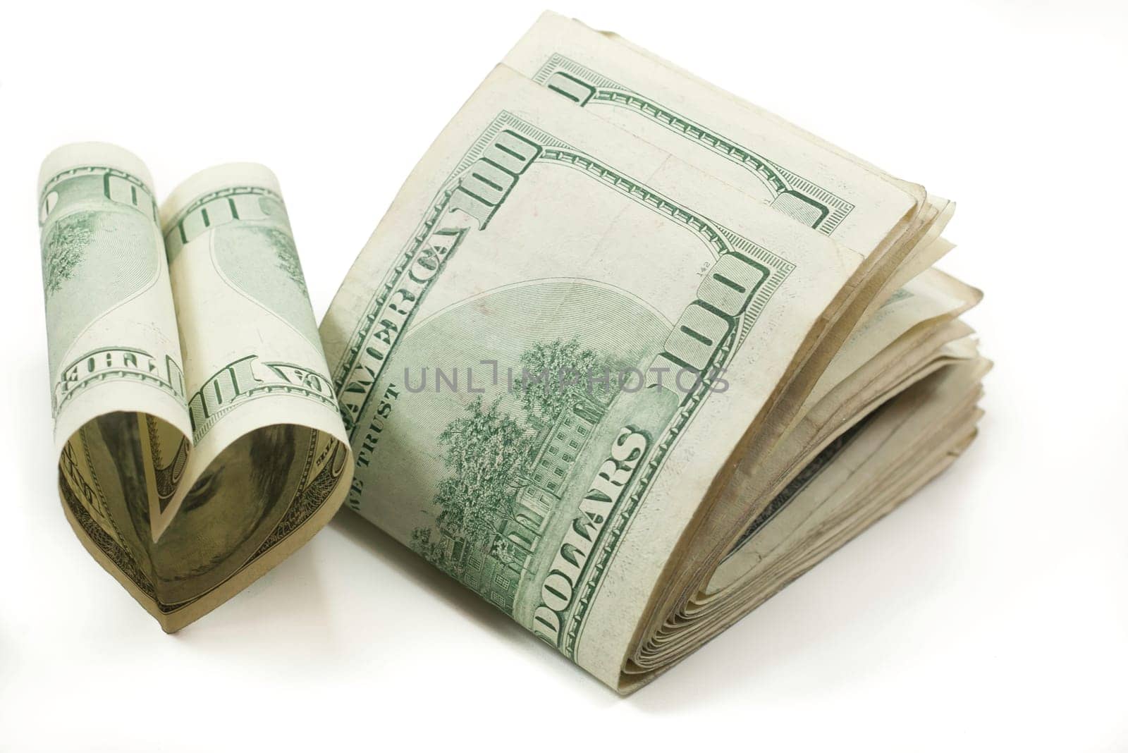 love of money stack of folded 100 dollar bills one shaped like a heart