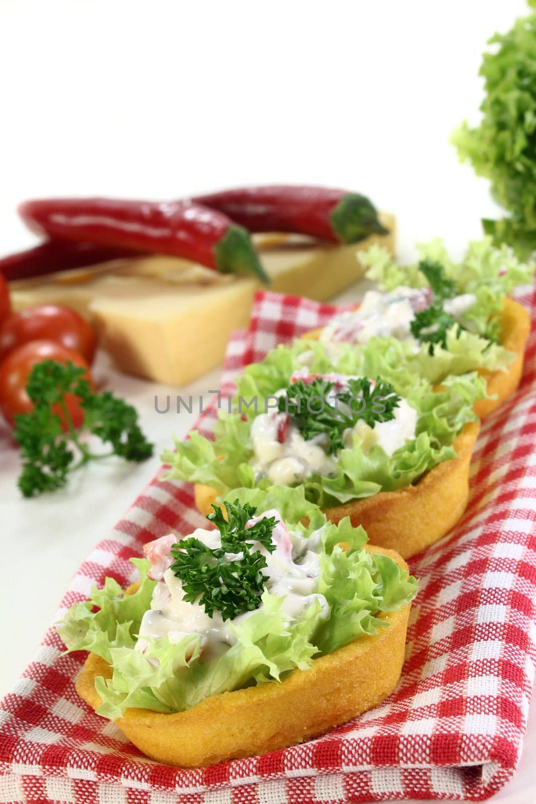 Corn tartlets with cheese salad against white background
