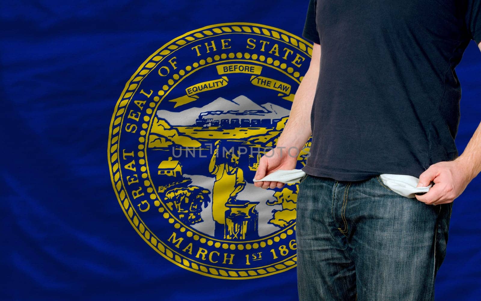 poor man showing empty pockets in front of american state of nebraska flag