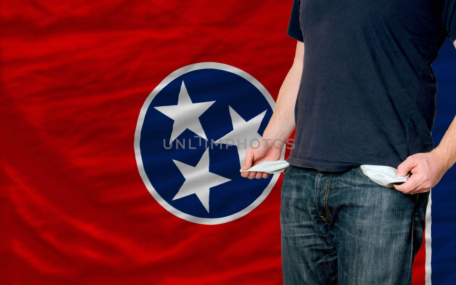 poor man showing empty pockets in front of american state of tennessee flag