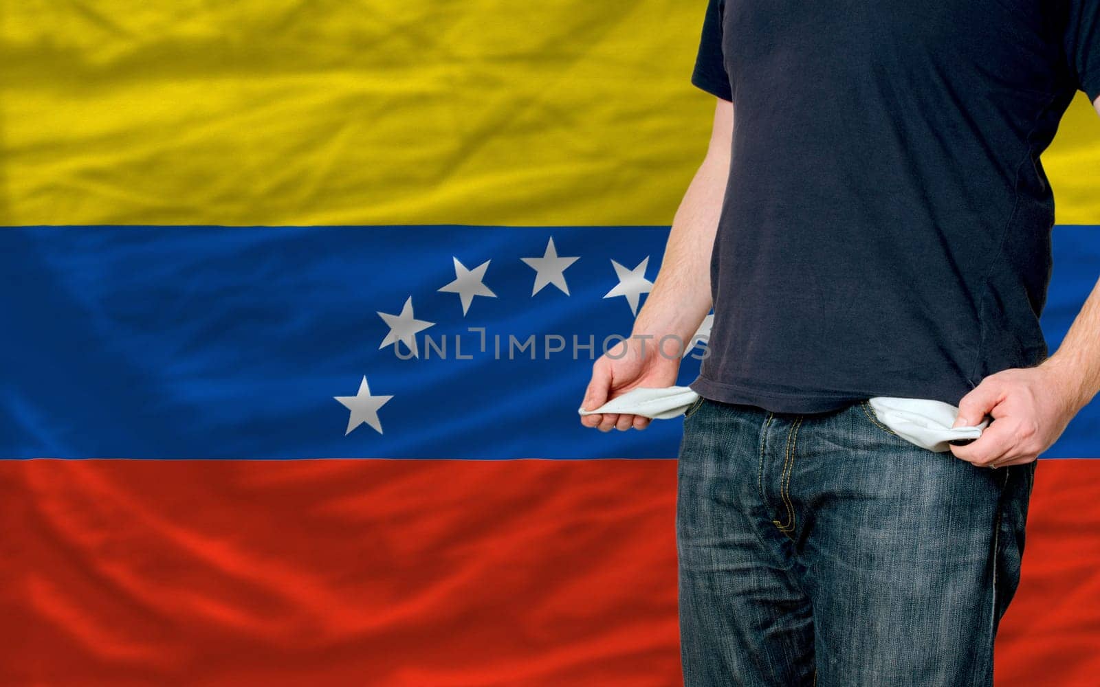 poor man showing empty pockets in front of venezuela flag