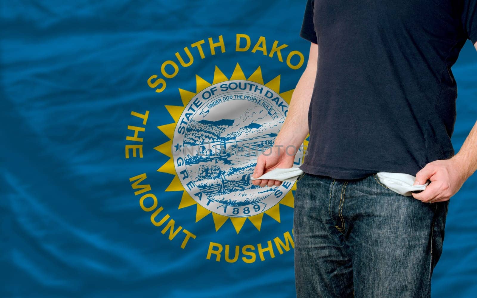 poor man showing empty pockets in front of american state of south dakota flag