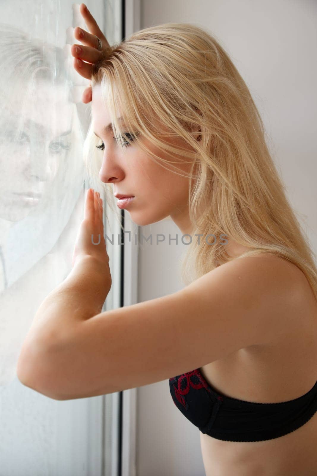 Portrait of sadness young woman near window