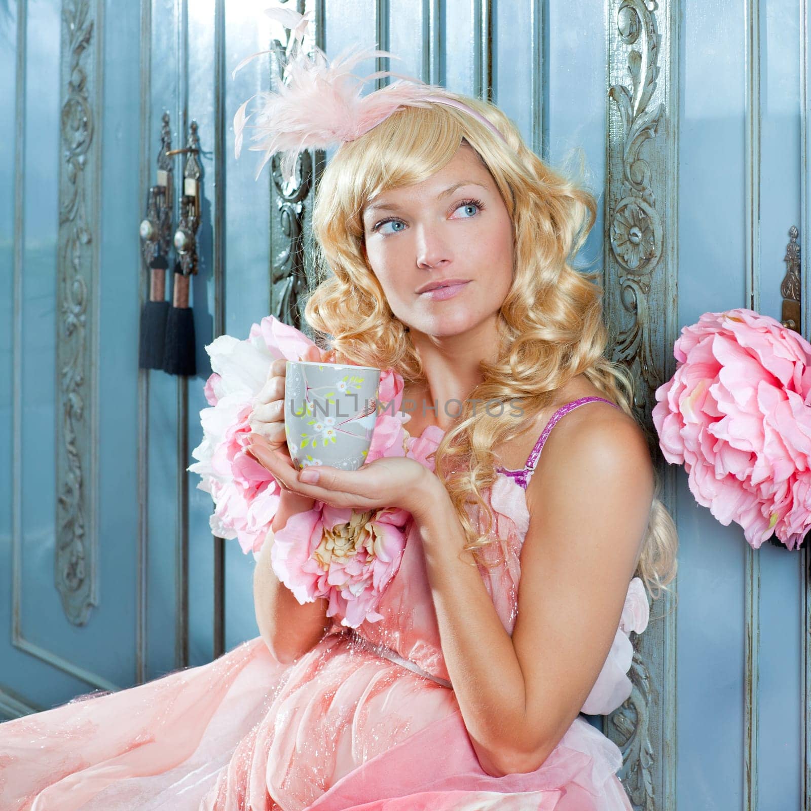 blond fashion princess woman drinking tea or coffee at home with vintage pink dress