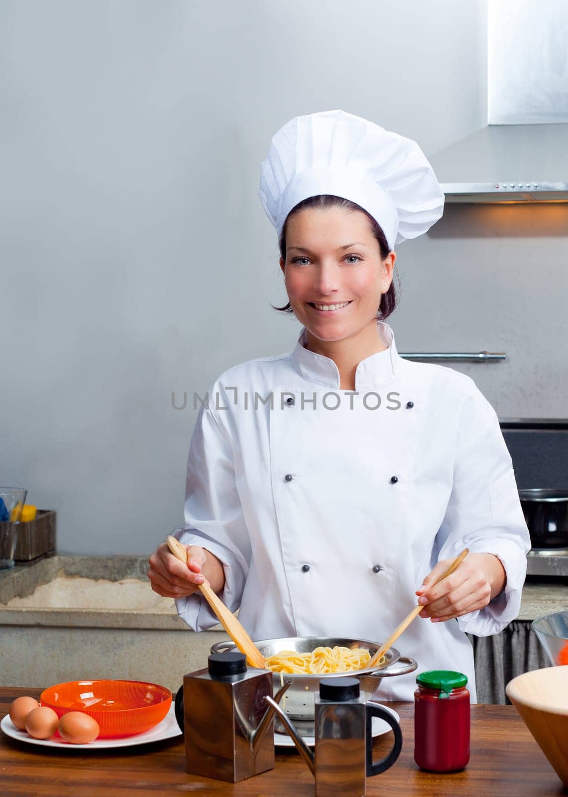 Chef woman portrait with white uniform in the kitchen
