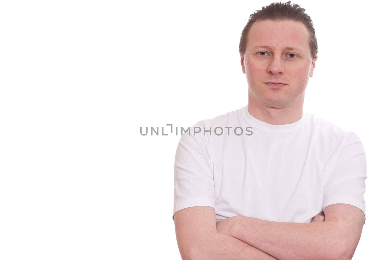 A man in a white T-shirt looks relaxed with a smile