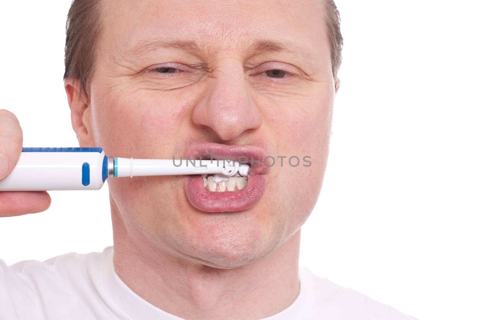 European with an electric toothbrush brushes his teeth