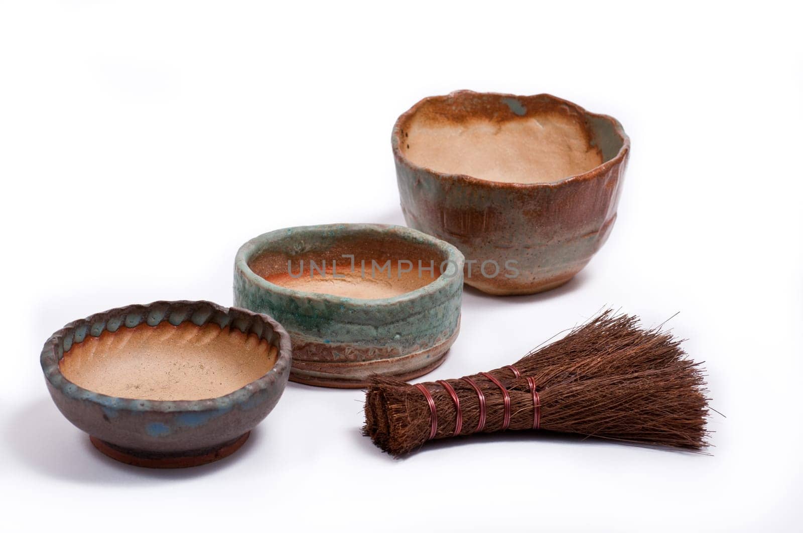 Three kusamono bowls fired from clay and with colored glaze and a hand broom for bonsai