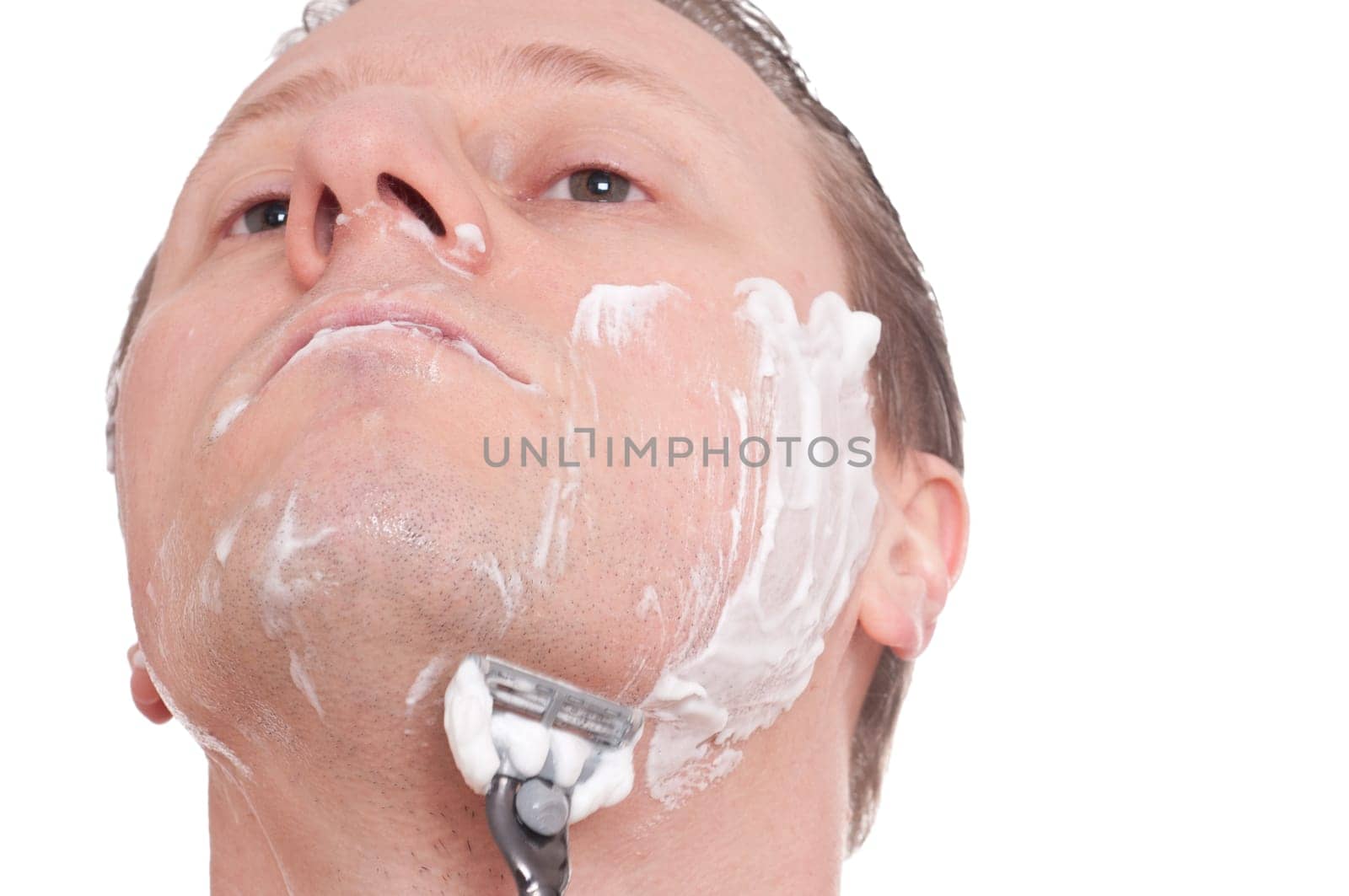 A man shaves wet with a razor blade