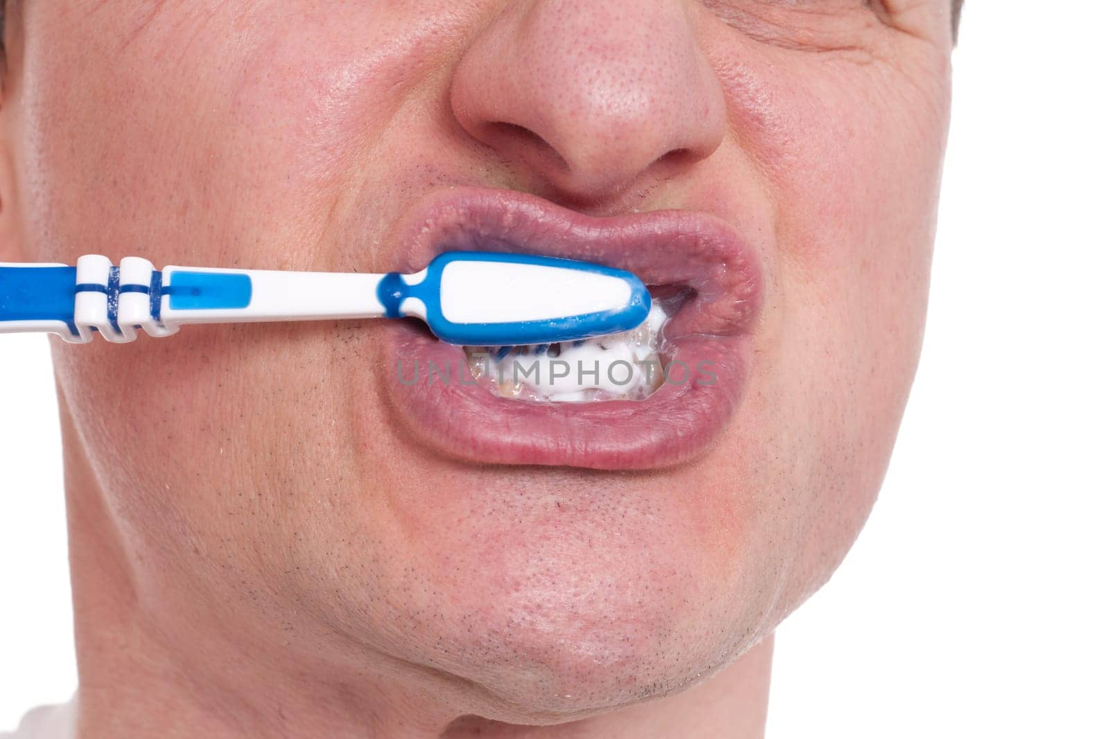 A European brushes his teeth with a hand toothbrush