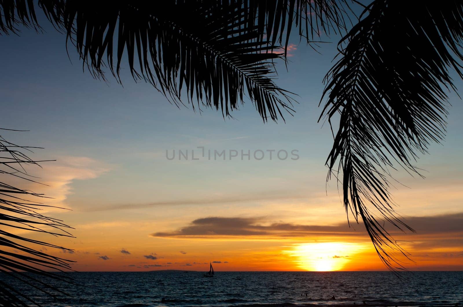 tropical beach with sailing boats at sunset