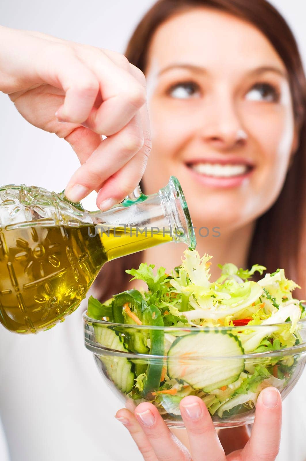 young woman pouring olive oil close up