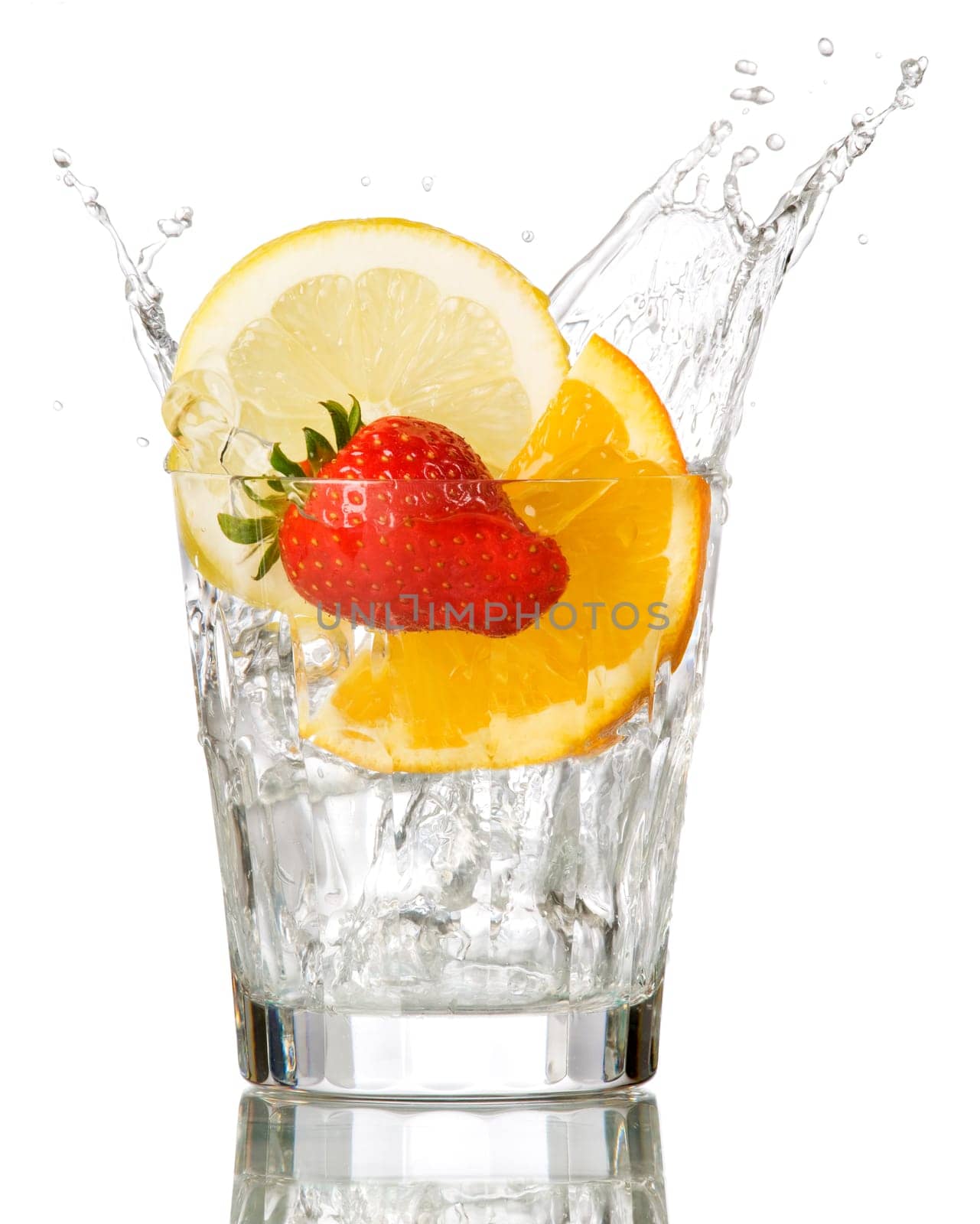 splashing orange, lemon and strawberry into a water glass