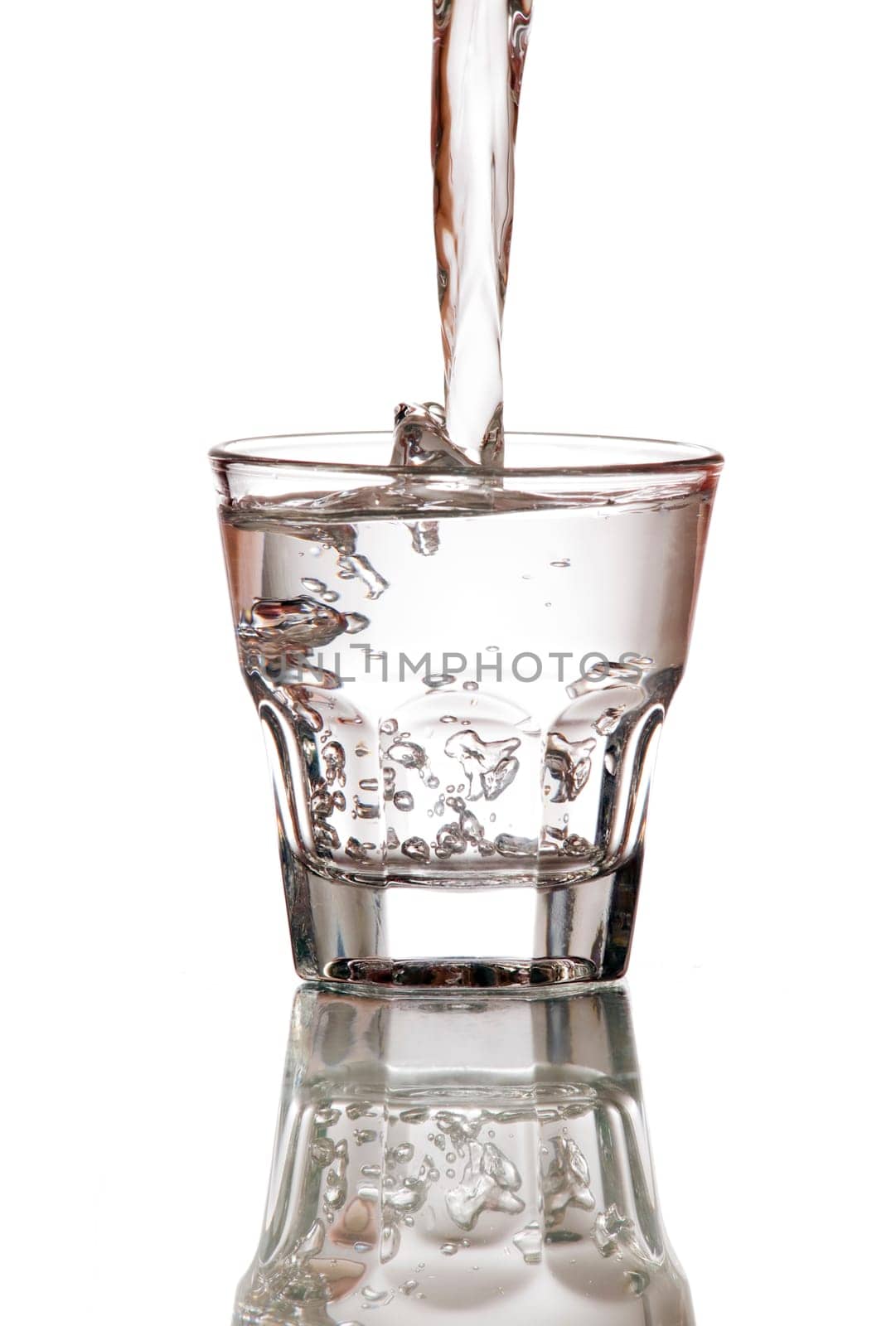fresh water splashing into glass isolated on white