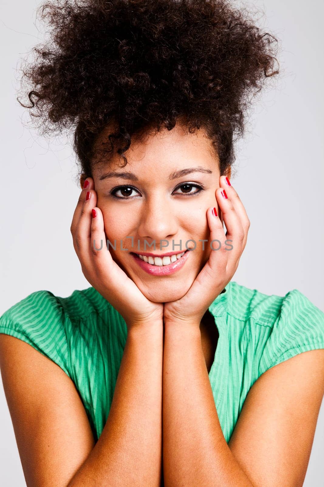 Beautiful woman with hands on cheeks looking at the camera. Studio shot.