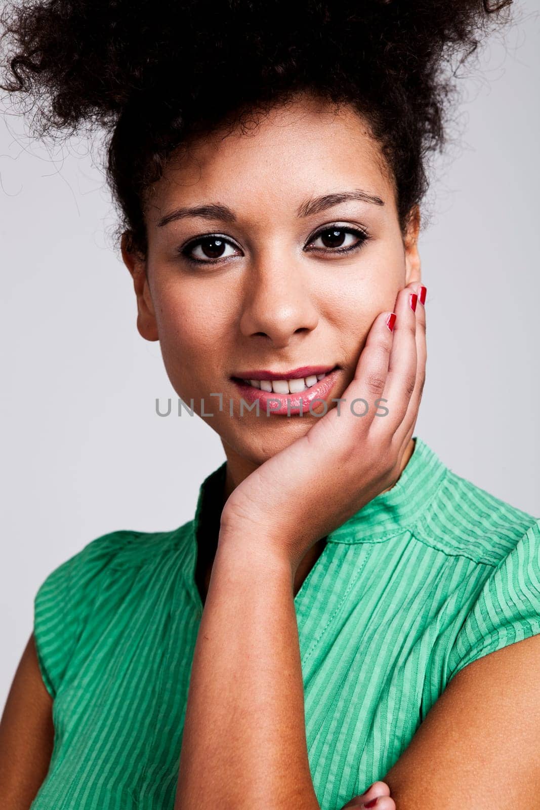 Portrait of a beautiful woman with hand on cheek. Studio shot.