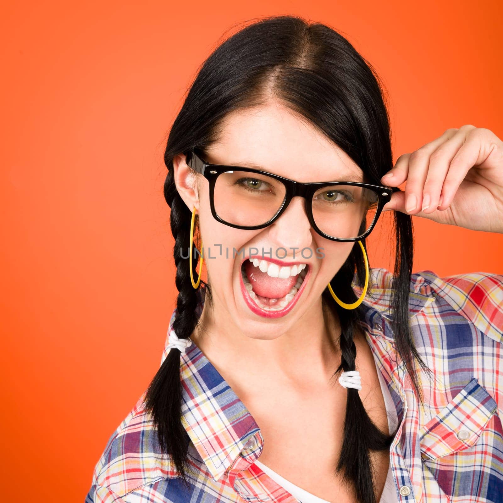 Crazy girl wear nerd glasses shouting on orange background