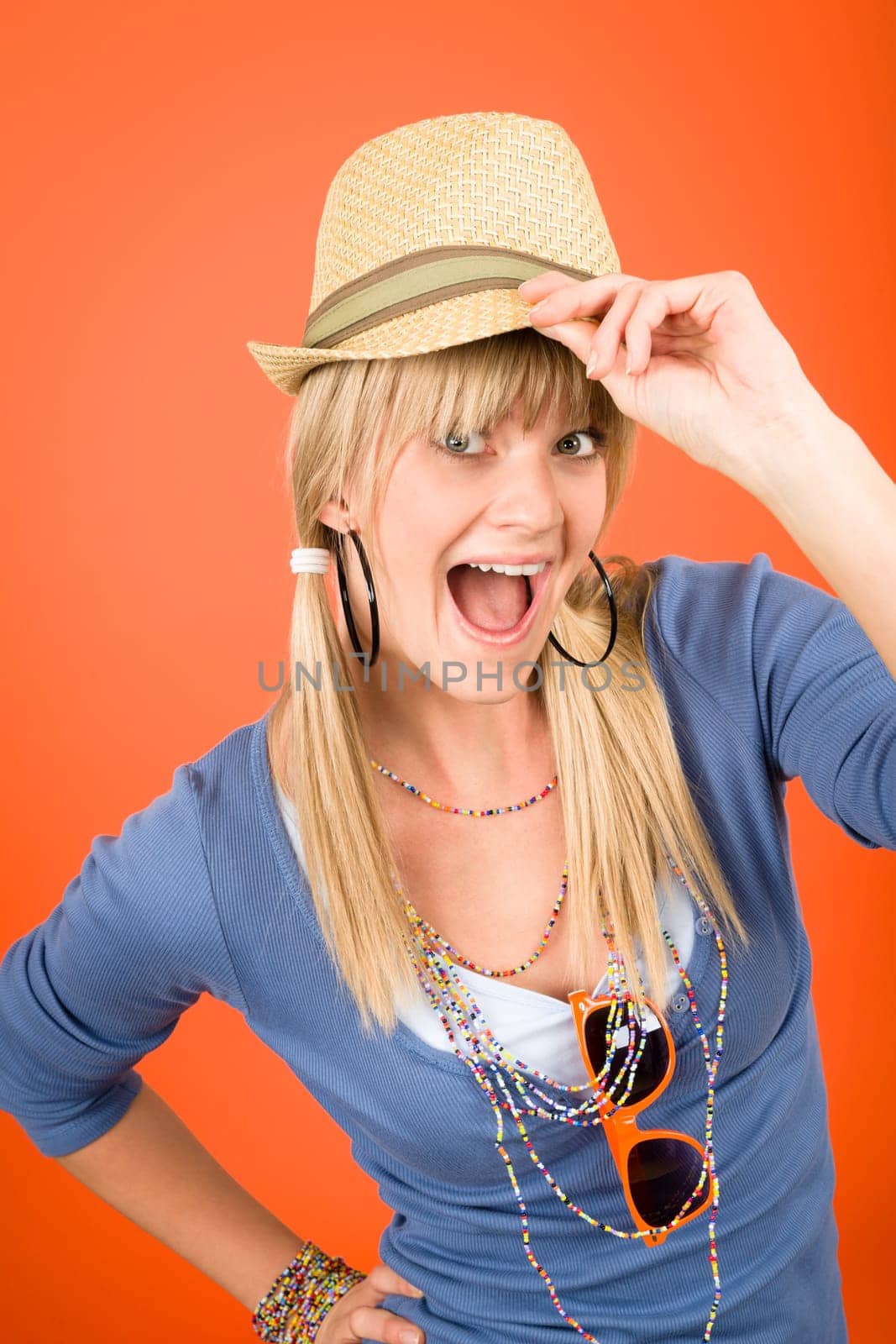 Crazy blond girl wear hat shouting on orange background