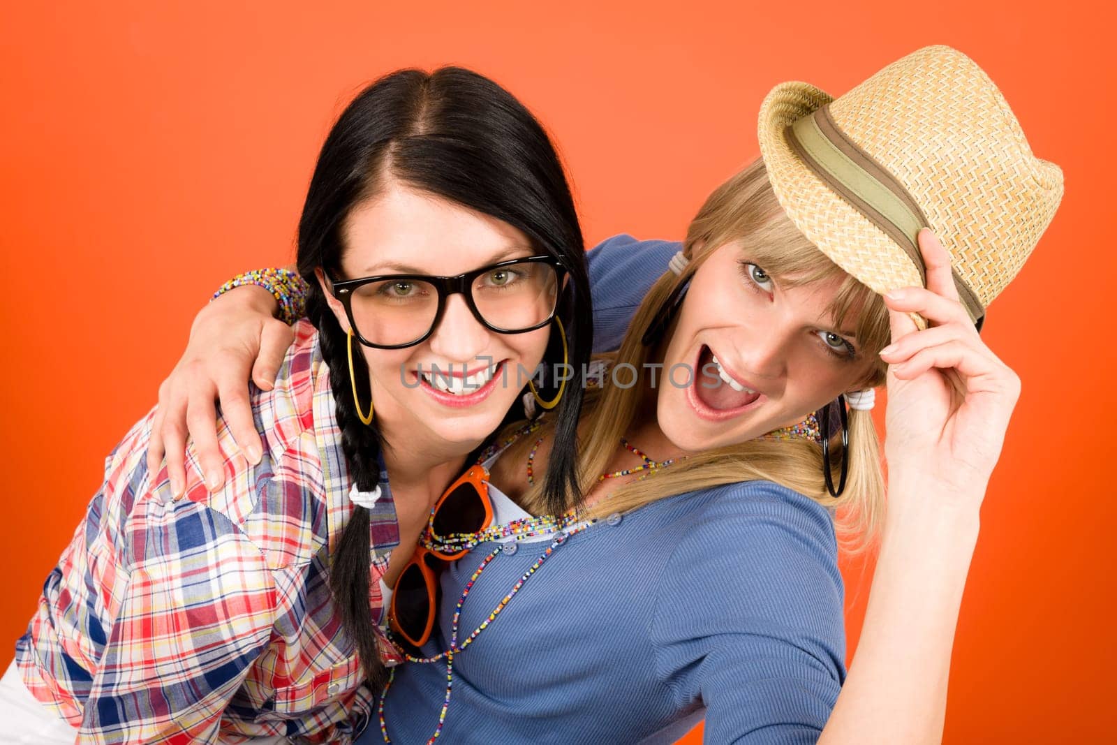 Two woman friends young have fun crazy smiling orange background