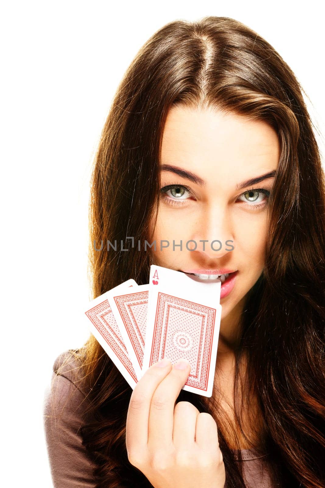 Young woman biting into poker card on white background